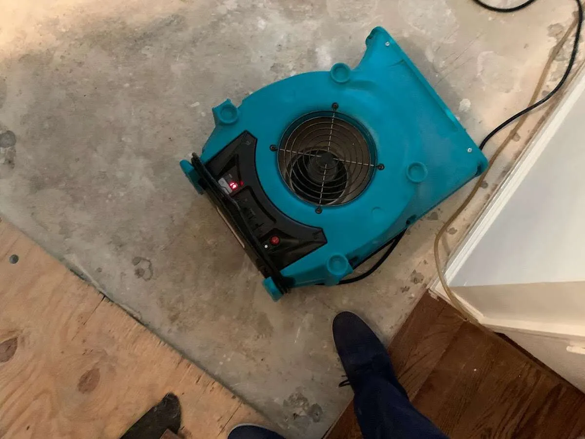 Air mover drying subfloor during Commercial Water Damage Restoration in West Caln